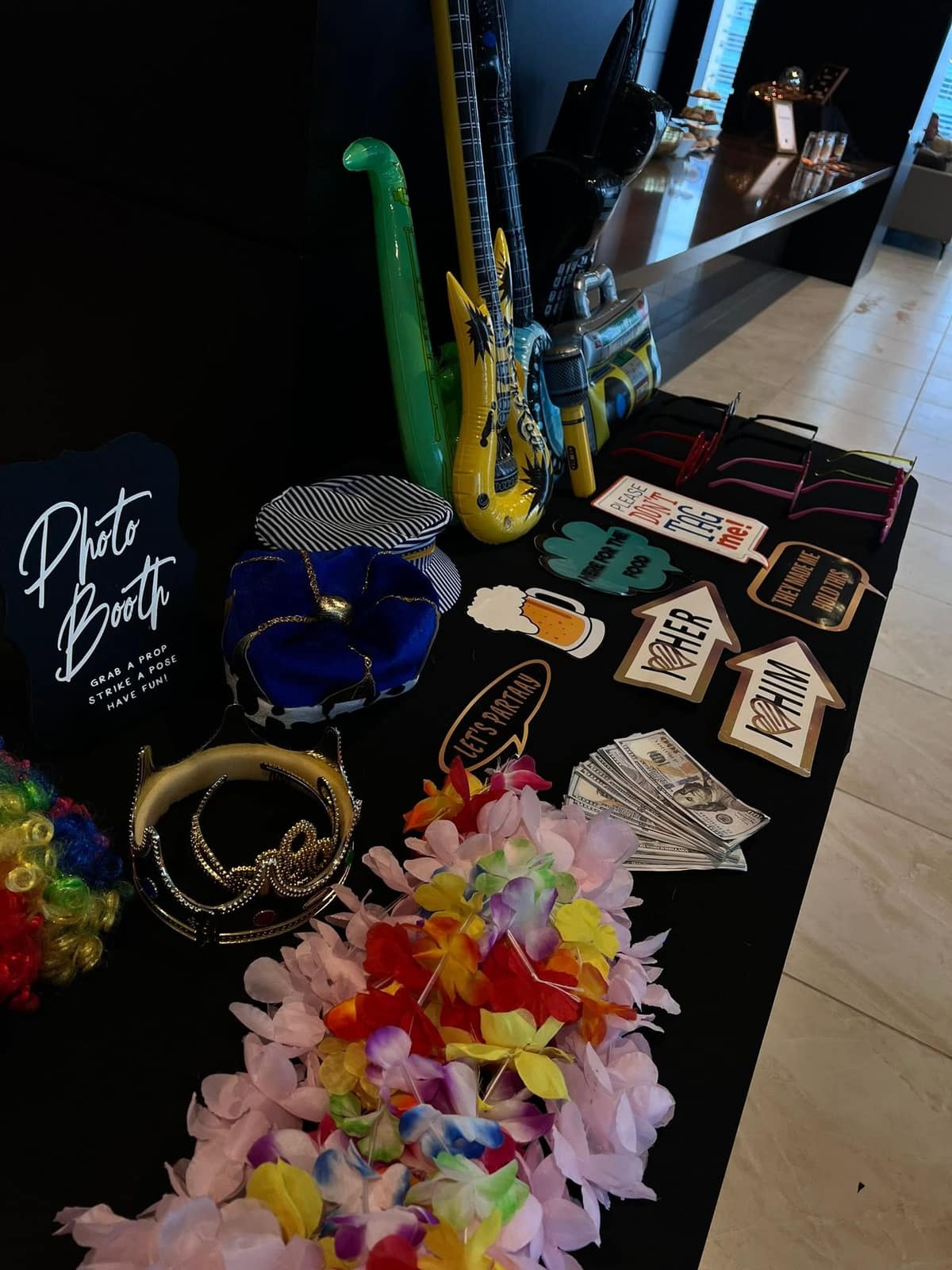 Prop table with crowns, signs, and leis ready for guests